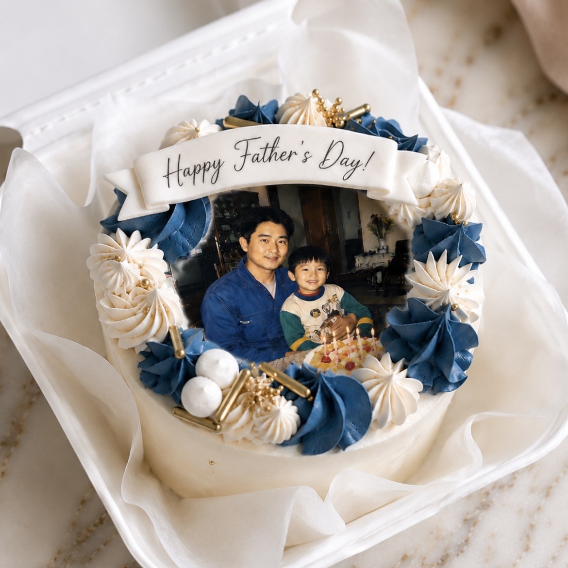 Cake featuring a printed photo of a man and child, with a 'Happy Father's Day!' ribbon and blue-white frosting decorations.