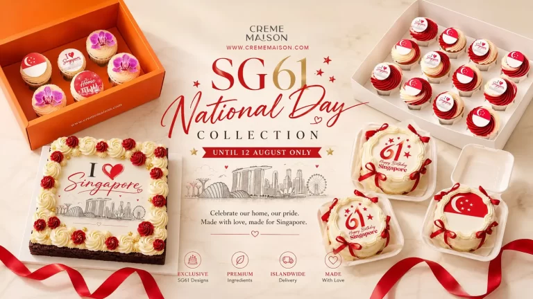 Assorted Singapore National Day desserts: a decorated cake, cupcakes with flag toppers, and gift boxes on a marble surface.
